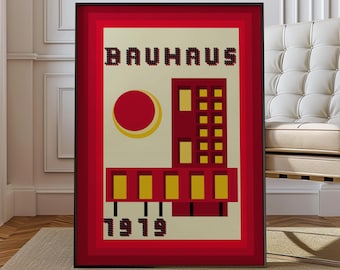 Op de afbeelding: Een ingelijste Bauhaus kunstprint. Het kunstwerk toont een rood en geel geometrisch ontwerp met het woord "BAUHAUS" bovenaan en het jaartal "1919" onderaan. De print is ingelijst in een zwart frame met een rode rand.