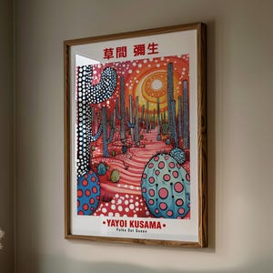 May include: A framed art print featuring a desert landscape with stylized cacti and a vibrant color palette. The artwork includes the text "YAYOI KUSAMA" and "Polka Dot Queen". The print is in a wooden frame.