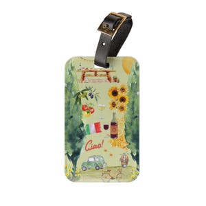 May include: A luggage tag with a black leather strap and gold buckle. The tag features a watercolour illustration of Italian imagery, including sunflowers, wine, pasta, and a vintage car. The word "Ciao!" is written on the tag.