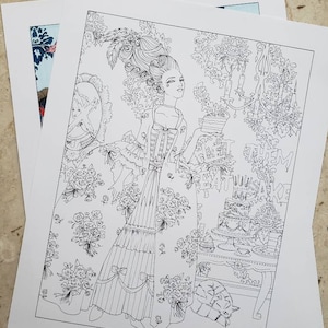May include: Black and white line art print featuring a woman in a period dress holding a cake. The print includes floral patterns, a table with cakes, and the text "EAT CAKE".