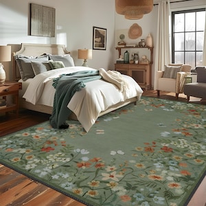 Peut inclure: Un tapis de sol vert &agrave; motifs floraux avec une bordure florale blanche et jaune. Le tapis est dans une chambre &agrave; coucher avec un lit blanc et une commode en bois.