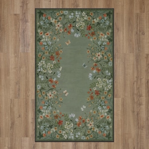 Peut inclure: Un tapis vert avec une bordure florale repr&eacute;sentant une vari&eacute;t&eacute; de fleurs et de papillons. Le tapis a un fond vert clair avec une bordure vert fonc&eacute;.