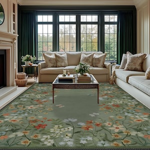 Peut inclure: Un tapis de salon vert &agrave; motifs floraux beiges, cr&egrave;me et orange. Le tapis est dans un salon avec deux canap&eacute;s beiges, une table basse en verre et des rideaux verts.