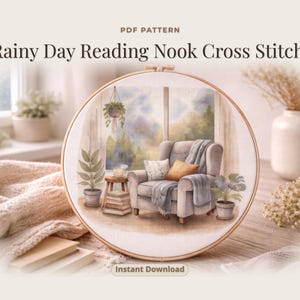 Puede incluir: Un patrón de punto de cruz en un aro de madera, que presenta una acogedora escena de rincón de lectura. El diseño incluye un sillón gris, almohadas, una mesa auxiliar con libros y plantas en macetas. El texto dice "Rainy Day Reading Nook Cross Stitch" e "Instant Download".