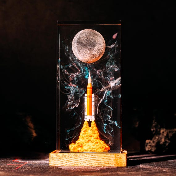 A resin lamp with an actual Artemis II rocket launch scene frozen inside — the kind of desk piece that makes visitors stop and ask 'wait, what IS that?'