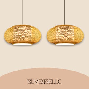 May include: Two pendant lights with woven bamboo shades. The shades are oval-shaped with a lattice design, emitting a warm glow. The lights hang from black cords against a neutral background. The text "BUYENSELLC" is at the bottom.