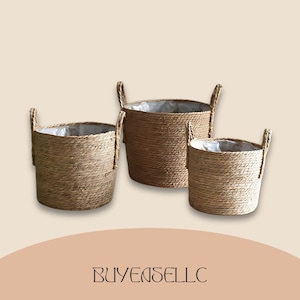 May include: Three woven plant baskets of different sizes. The cylindrical baskets have built-in handles and are made from a light-coloured, natural fibre. Each basket has a clear plastic liner. The text "BUYENSELLC" is at the bottom.