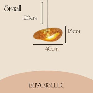 May include: A small, woven pendant light fixture. The light is 120cm long, 40cm wide, and 13cm high. The fixture is a warm, golden color and is suspended from a thin wire. The word "Small" is above the light.