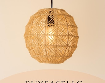 May include: A woven pendant light fixture with a spherical shape. The light is made of natural-colored twine, creating a geometric pattern. The light hangs from a black cord and illuminates a warm glow. The text "BUYEASELLC" is at the bottom.