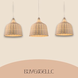 May include: Three woven pendant lights with a natural, light beige color. The lamps have a bell-shaped design and hang from thin cords. The text "BUYENSELLC" is at the bottom of the image.