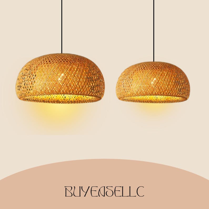 May include: Two woven bamboo pendant lights with a warm, golden glow. The lamps have a dome shape and are suspended from black cords. The lamps are lit from within, casting a soft light. The text "BUYENSELLC" is at the bottom.