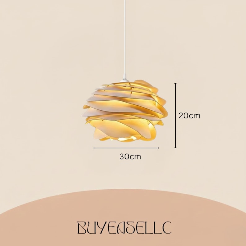 May include: A modern, layered pendant light fixture. The light is a warm gold color, with a diameter of 11.8 inches and a height of 7.9 inches. The fixture is suspended from a white cord.