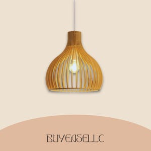 May include: A wooden pendant light fixture with a warm, natural finish. The light has a unique, open design with vertical slats, creating a stylish, modern look. The light bulb is visible inside the fixture. The text "BUYENSELLC" is at the bottom.