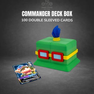 May include: A green Commander Deck Box with red and yellow accents, designed to hold 100 double-sleeved cards. The box has a blue feather-like detail on top. A card with a cartoon character is in front of the box. Text on the box reads "Commander Deck Box".