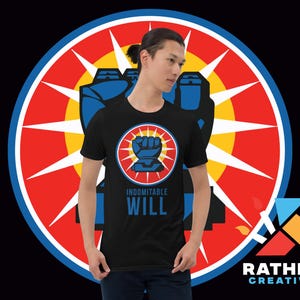 Puede incluir: Camiseta negra con un puño azul dentro de un círculo rojo y amarillo, con las palabras "INDOMITABLE WILL" en azul. El diseño está sobre un gran fondo circular rojo, azul y amarillo. La camiseta la lleva una persona.