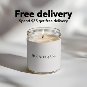 May include: A lit candle in a clear glass jar with a white label. The label reads "MUGNIFIQ USA". Above the candle, the text reads "Free delivery" and "Spend $35 get free delivery". The candle is on a white surface.