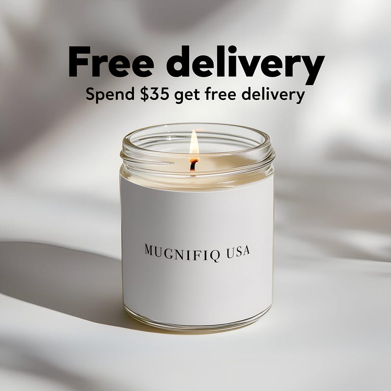 May include: A lit candle in a clear glass jar with a white label. The label reads "MUGNIFIQ USA". Above the candle, the text reads "Free delivery" and "Spend $35 get free delivery". The candle is on a white surface.