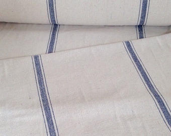 May include: Off-white fabric with vertical blue stripes. The fabric is folded and rolled, showcasing the texture and pattern. The stripes are evenly spaced and run the length of the material, creating a classic, simple design. Ideal for home decor or crafting projects.