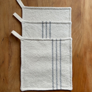 May include: Three white cotton pot holders with blue stripes. The pot holders have a loop handle.