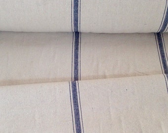 May include: Cream-colored fabric with vertical navy blue stripes. The fabric is rolled up, showing the texture and pattern. The stripes are evenly spaced, creating a classic, simple design. This textile is suitable for various home decor projects.