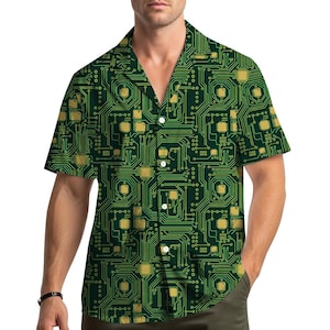 Peut inclure: Chemise verte à manches courtes avec un motif de circuit imprimé. La chemise a un col chemise et un motif de composants électroniques dorés et verts. Le motif est répété sur toute la chemise.