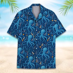 May include: A short-sleeved button-down shirt featuring a dark blue background with a repeating pattern of light blue octopuses, white seaweed, and small yellow starfish. The garment has a classic collar and a front button closure.