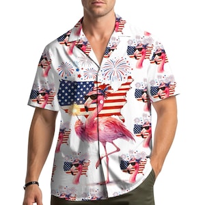 May include: White button-down shirt with a repeating pattern of a pink flamingo wearing sunglasses and a patriotic headband, holding a sparkler. The shirt also features fireworks and a map of the United States with the American flag.