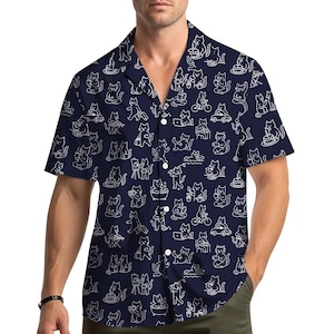May include: Navy blue button-down shirt with a white cat-themed pattern. The short-sleeved shirt features a repeating design of cats engaged in various activities, such as riding bikes, using laptops, and eating cake. The shirt has a classic collar and button closure.