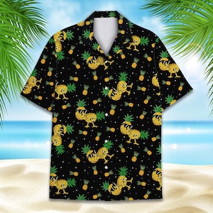 Puede incluir: Una camisa negra de manga corta con botones y un patrón repetitivo de piñas amarillas con gafas de sol negras. Las piñas están representadas con brazos y piernas en varias posturas sobre un fondo negro con pequeños puntos blancos.