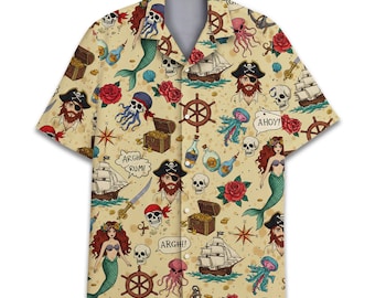 May include: A short-sleeved button-down shirt with a pirate-themed pattern. The beige shirt features illustrations of pirates, mermaids, ships, treasure chests, skulls, and nautical elements in red, blue, and yellow. The shirt has a classic collar and a relaxed fit.