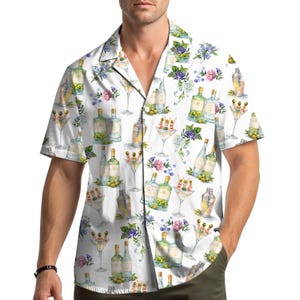 Op de afbeelding: Wit overhemd met korte mouwen met een herhalend aquarelpatroon van martiniglazen, flessen, olijven en bloemmotieven. Het overhemd heeft een klassieke kraag en een relaxte pasvorm.