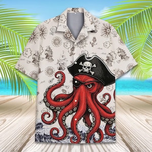 Puede incluir: Camisa blanca con botones con un diseño de temática pirata. La camisa presenta un pulpo rojo con un sombrero de pirata y un parche en el ojo. El fondo tiene elementos náuticos como brújulas, barcos y anclas.