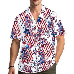 Könnte beinhalten: Weißes Hemd mit Knopfleiste und patriotischem Skelettmuster. Das Design zeigt Skelette mit Zylindern, rote und blaue Sterne, Streifen und Feuerwerk. Das kurzärmelige Hemd ist eine festliche Wahl für Feierlichkeiten.