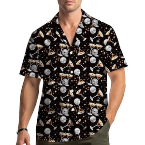 May include: Black short-sleeved shirt featuring a pattern of martini glasses, disco balls, and coffee beans. The shirt has a classic collar and a relaxed fit. The design includes white stars on a black background.