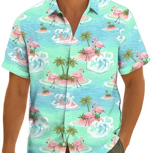 Könnte beinhalten: Kurzärmeliges Button-Down-Hemd mit tropischem Flamingodruck. Das Hemd hat einen hellblauen und grünen Hintergrund mit rosa Flamingos, Palmen und Meereswellen. Das Hemd hat einen klassischen Kragen und eine Tasche auf der Brust.