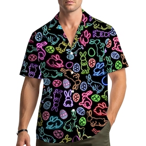 May include: Black button-down shirt with a neon Easter-themed pattern. The design features colorful neon bunnies and Easter eggs in shades of pink, yellow, green, and blue. The shirt has short sleeves and a relaxed fit.