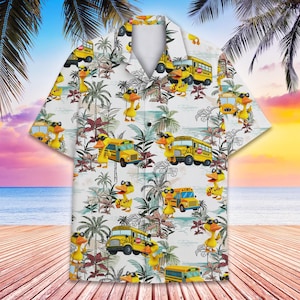 May include: White short-sleeved shirt with a tropical print. The pattern includes yellow school buses and cartoon ducks wearing sunglasses. The shirt has a classic collar, ideal for a relaxed, summery style.