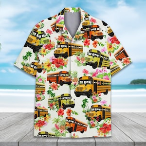 Puede incluir: Camisa de manga corta con fondo blanco, con un estampado repetido de autobuses escolares amarillos, naranjas y verdes, intercalados con flores tropicales y palmeras. La camisa tiene un cuello clásico y un corte relajado.