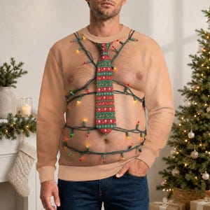 Peut inclure: Un sweat-shirt à col rond et manches longues avec un imprimé réaliste de couleur chair, un motif de cravate à motifs de Noël verts et rouges, et une guirlande de lumières de Noël colorées enroulée autour du torse du vêtement.
