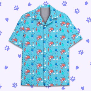 May include: A blue short-sleeved button-up shirt with a repeating pattern of a cartoon cat wearing a taco and a blue drink. The cat is surrounded by lightning bolts, stars, and other geometric shapes.