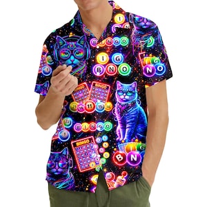 May include: Short-sleeved button-down shirt with a vibrant, colorful design. The shirt features a repeating pattern of cats wearing headphones and glasses, bingo cards, and bingo balls. The background is a dark, starry night sky.
