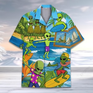 May include: A blue and green Hawaiian shirt with a pattern of aliens surfing and hula dancing. The shirt has a button-up front and short sleeves.