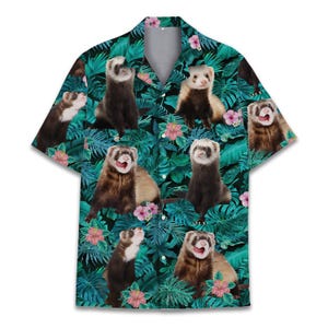 May include: Short-sleeved shirt with a repeating pattern of ferrets. The shirt has a tropical design with large green leaves, pink flowers, and a dark teal background. The shirt has a button-down collar.