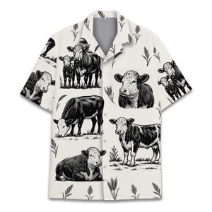 May include: White button-up shirt with a black and white cow illustration pattern. The short-sleeved shirt features a collared neckline and a relaxed fit, suitable for casual wear. The cow illustrations are detailed and repeated across the fabric.