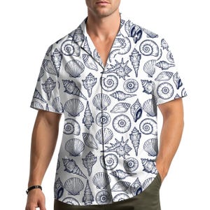 以下が含まれることがあります： 白の半袖シャツ。青い貝殻のイラストが繰り返されるパターン。シャツはクラシックな襟とリラックスしたフィット感で、カジュアルウェアに適しています。