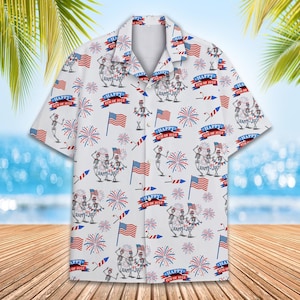 May include: White button-up shirt with a pattern of skeletons holding American flags and fireworks. The text "Happy 4th of July" is repeated throughout the pattern.