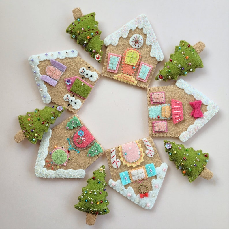 May include: Nine felt ornaments in the shape of gingerbread houses and Christmas trees. The houses are decorated with white frosting, candy canes, and colorful details. The trees are green with white and gold embellishments.