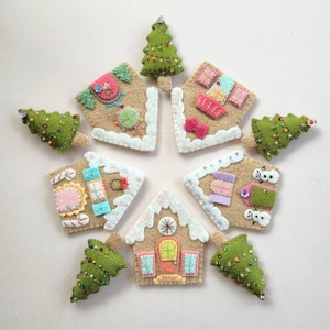 May include: Nine felt ornaments in the shape of gingerbread houses and Christmas trees. The ornaments are decorated with colorful details and beads.