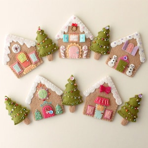 May include: Nine felt Christmas ornaments, including gingerbread houses and Christmas trees. The houses are decorated with candy canes, bows, and windows. The trees are green with white lights.