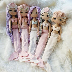 May include: Five handmade mermaid dolls with long, flowing hair and colourful tails. The dolls are dressed in different colours and have different facial features.